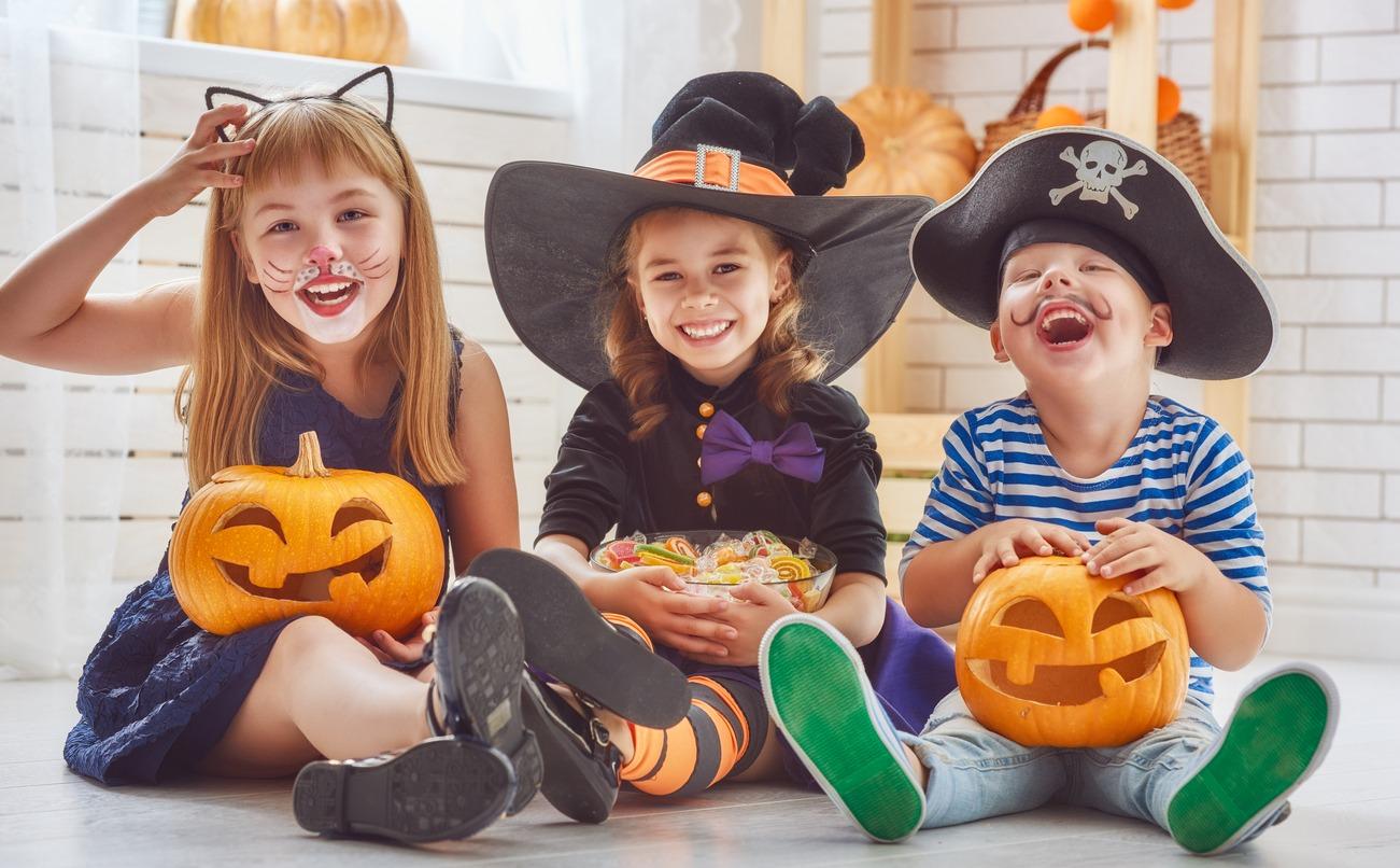 Three kids dressed up ready to go enjoy a halloween festival.