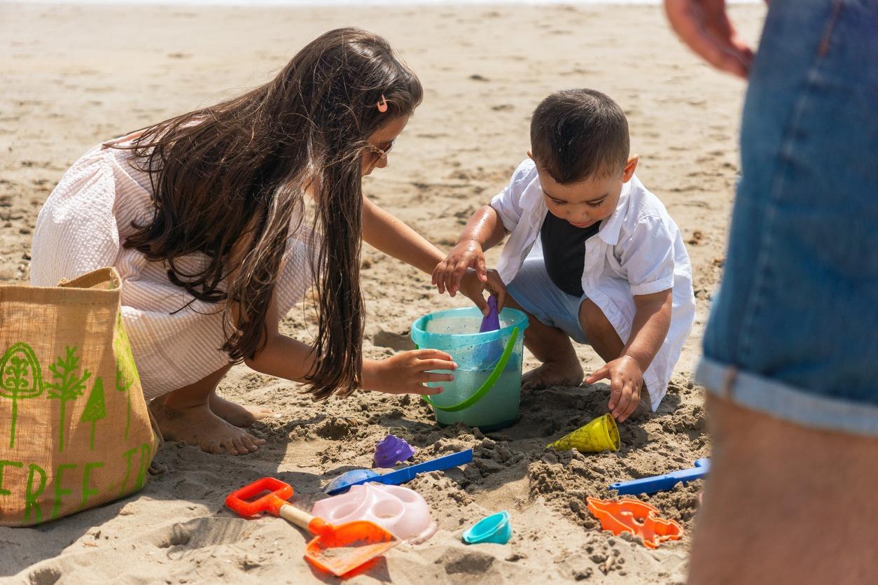 kids playing in the same making a sandcastle.